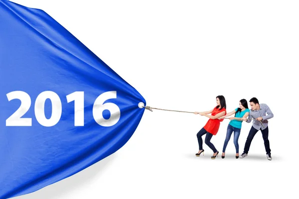 Молодые люди тянут знамя с цифрами 2016 — стоковое фото