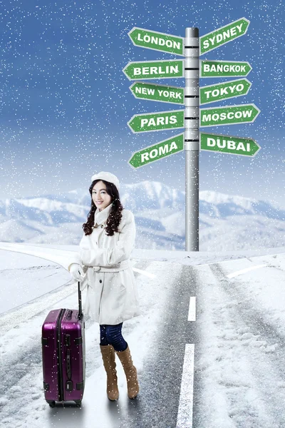 Woman with winter destination vacation choices — ストック写真