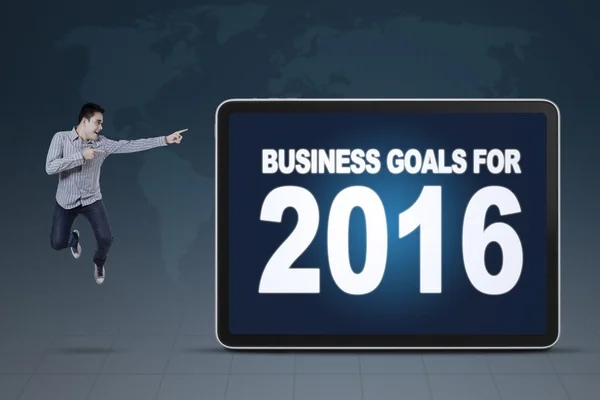 Man jumping while pointing at business goals for 2016 — Stok fotoğraf