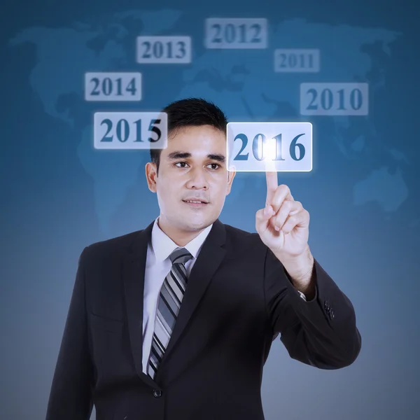 Man pressing numbers 2016 on the futuristic screen — Stockfoto