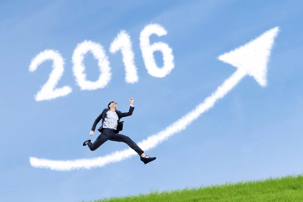 Worker jumps with numbers 2016 and upward arrow in sky — 图库照片