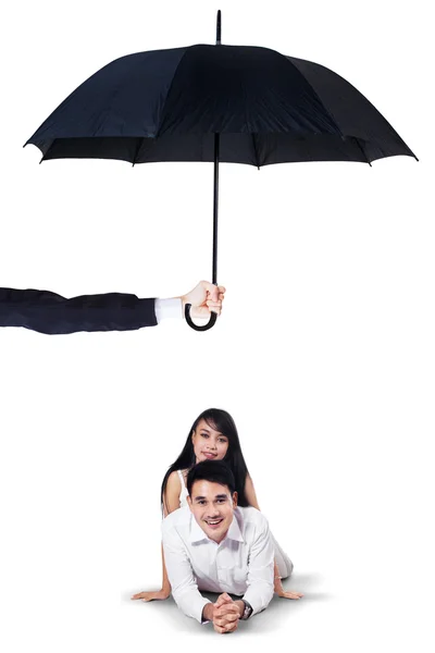 Two couple lying in studio under umbrella — Stok fotoğraf