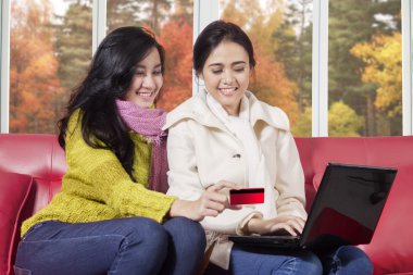 Kızlar sonbahar arka plan ile online alışveriş