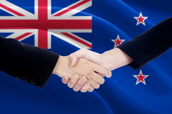 Händedruck mit Fahne von Neuseeland — Stockfoto