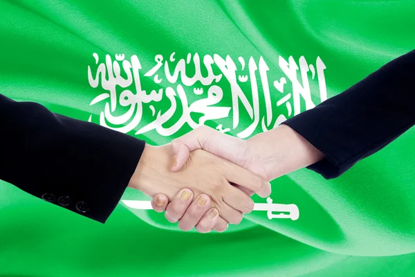 Apretón de manos con la bandera de Arabia Saudita — Foto de Stock