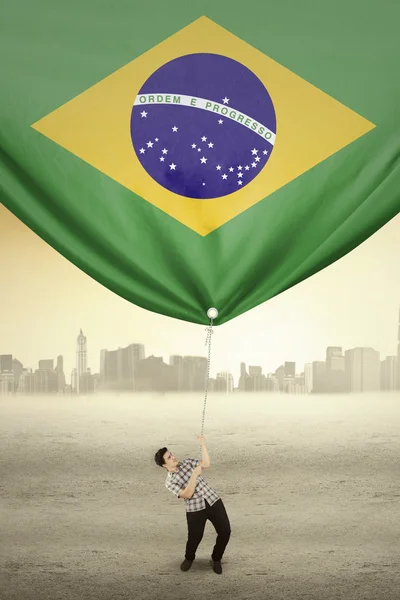 Bonito homem puxando bandeira do Brasil — Fotografia de Stock