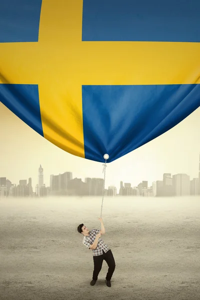 ハンサムな人はスウェーデンの国旗をドラッグします。 — ストック写真