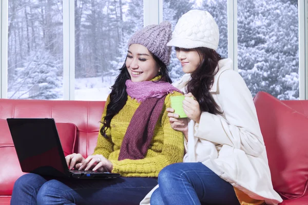 Pretty girls in winter clothes using laptop — Stock Photo, Image