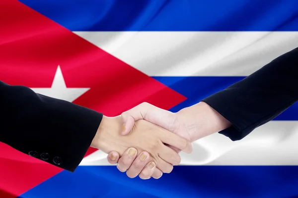 Dos personas estrechando la mano con la bandera de Cuba — Foto de Stock