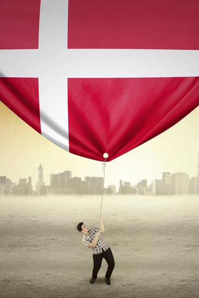 Young man drags flag of Denmark — Stock Photo, Image