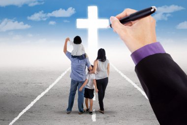 Hand guiding a family to the cross