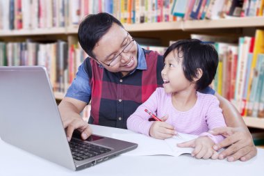 Öğretmen kız öğrenci kitaplığı ile konuşurken