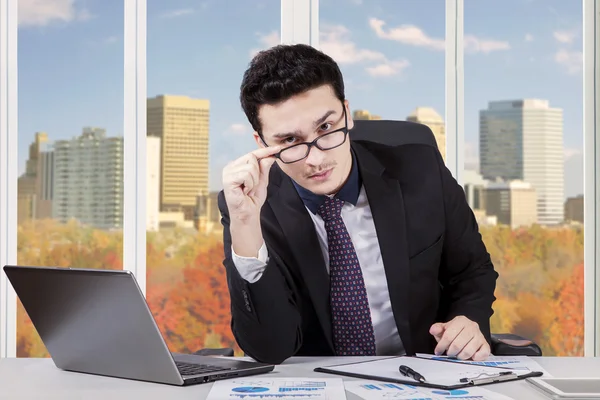 Uomo d'affari che fissa la telecamera in ufficio — Foto Stock