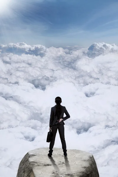 Businesswoman standing at mountain — Stockfoto