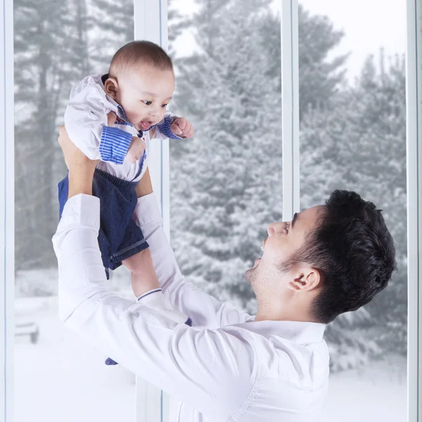 Cheerful father with male baby at home — 图库照片