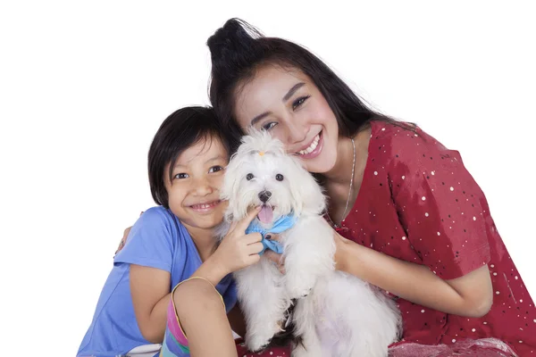 Menina bonito e sua mãe segurando cão no estúdio — Fotografia de Stock