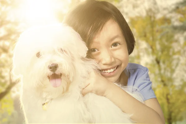 Cute girl holding her puppy at the park — Stockfoto