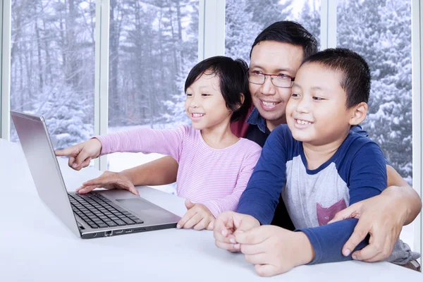 Lindos niños viendo la película en el ordenador portátil con papá — Foto de Stock