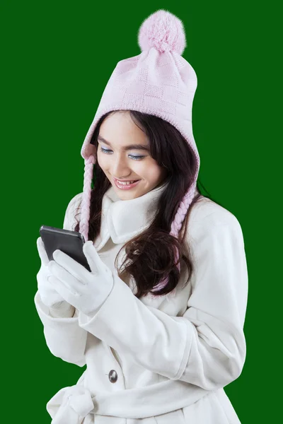 Girl in winter clothes texting with cellphone — 图库照片