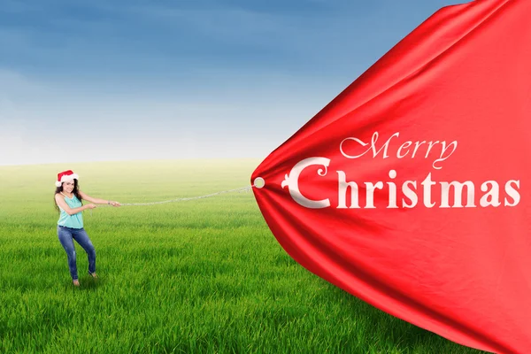 Indian woman pull a christmas banner — Stock Photo, Image