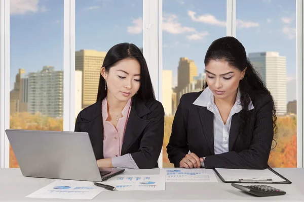 Twee multiraciale zakenvrouwen bespreken in office — Stockfoto