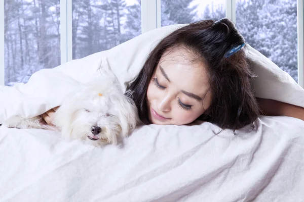 Vrouw en haar hond slapen op bed — Stockfoto