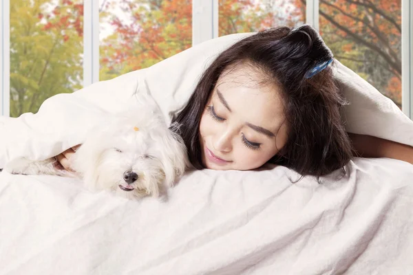 Köpeğiyle yatakta uyuyan kadın — Stok fotoğraf