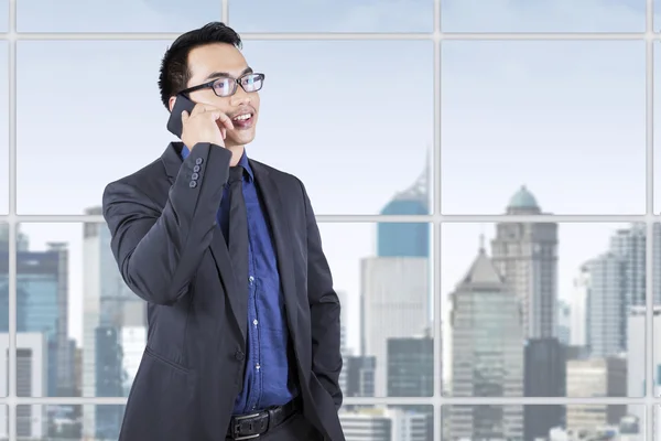 Young male entrepreneur talking on cellphone — Stock Photo, Image