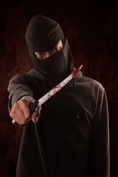Terrorist holding a knife with blood on it — Stock Photo, Image