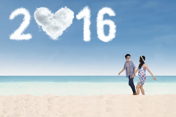 Couple marchant à la plage avec des chiffres 2016 — Photo