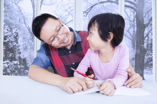 Linda chica estudiando con su padre en casa — Foto de Stock