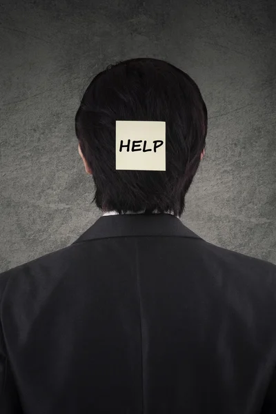 Männlicher Arbeiter mit einem Hilfetext auf dem Kopf — Stockfoto