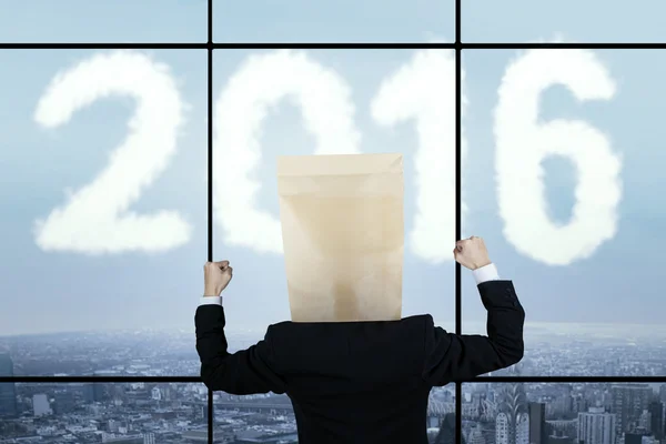 Man with carton head and numbers 2016 in office — Stock Photo, Image