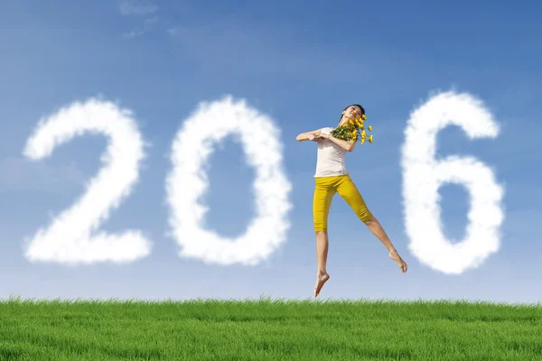 Pretty woman jumps at field with numbers 2016 — Stock Photo, Image