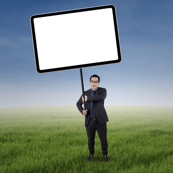 Businessperson holds billboard on the field — Stock Photo, Image