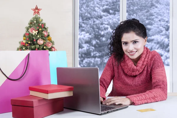 Modelo feminino com laptop e sacos de compras — Fotografia de Stock