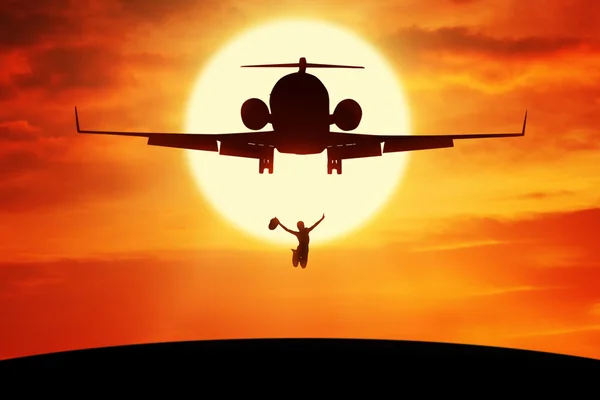 Jubelnde Frau springt unter fliegendes Flugzeug — Stockfoto