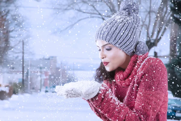 Cheerful indian woman blowing snow on her palm — Stock Photo, Image