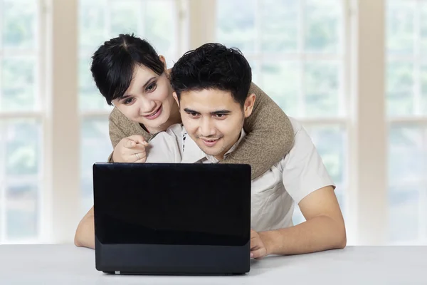 Família feliz com laptop em casa — Fotografia de Stock