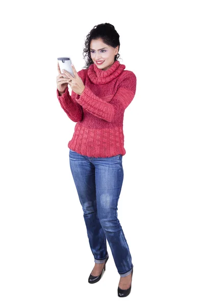 Indiase vrouw trui en texting dragen op mobiel — Stockfoto