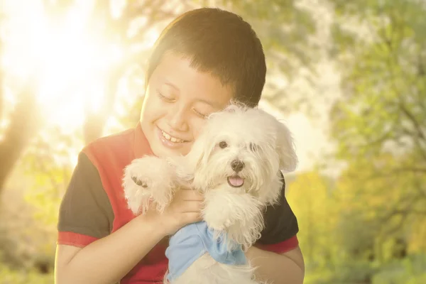 公園で彼の犬を抱いて少年 — ストック写真