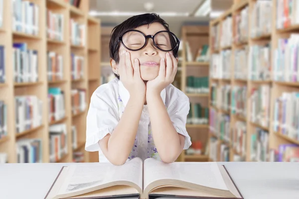 Mooie kind dagdromen in de bibliotheek — Stockfoto