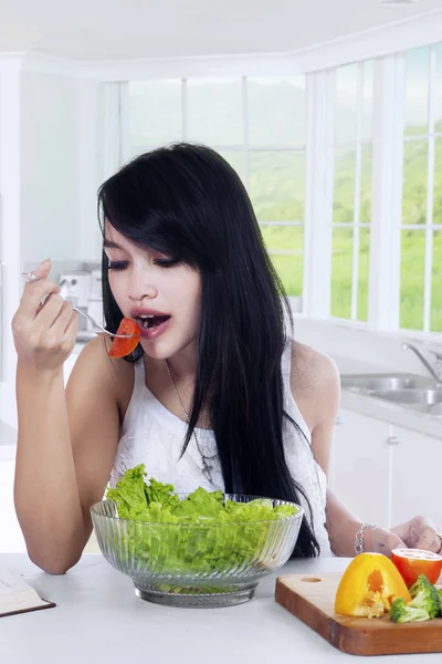 Ładna dziewczyna jedzenie świeże sałatki w kuchni — Zdjęcie stockowe