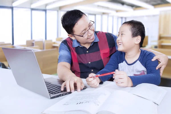 Lehrer im Gespräch mit einem männlichen Schüler in der Klasse — Stockfoto