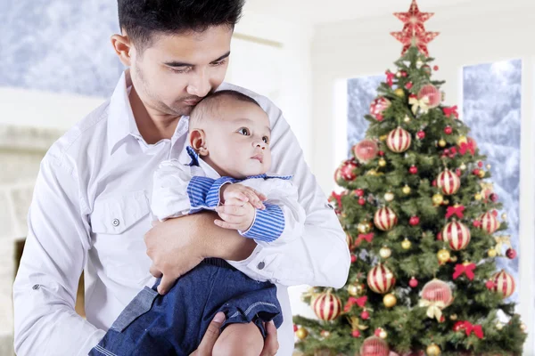 Vader en zijn baby met kerstboom thuis — Stockfoto