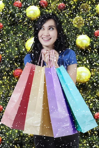 Радостный покупатель держит рождественские сумки — стоковое фото
