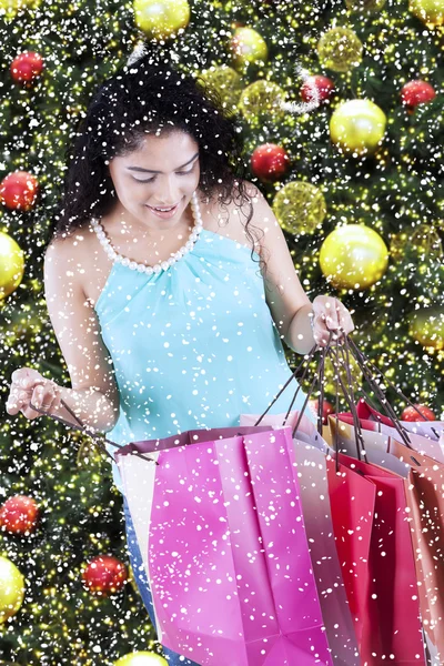 Indiase vrouw opent christmas shopping tassen — Stockfoto