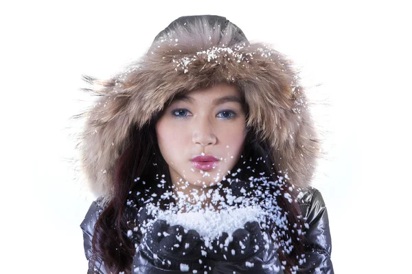 Ragazza adolescente soffiando neve in studio — Foto Stock