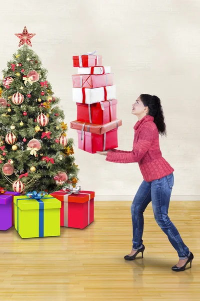 Frau trägt Weihnachtsgeschenke zu Hause — Stockfoto