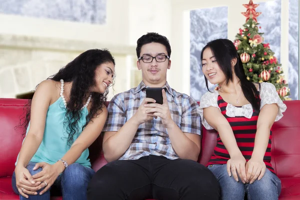 Due ragazze curiose sbirciare il messaggio il loro amico — Foto Stock